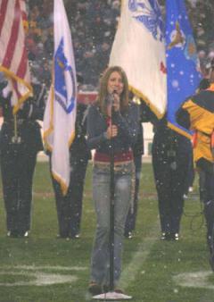 Photo of Julie Dubela singing the National Anthem at Patriots football game