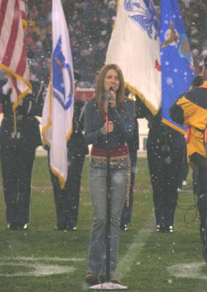 Photo of Julie Dubela singing the National Anthem at Patriots football game