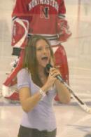 Photo of Julie Dubela singing the National Anthem at UNH hockey game