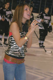 Photo of Julie Dubela singing the National Anthem at hockey game