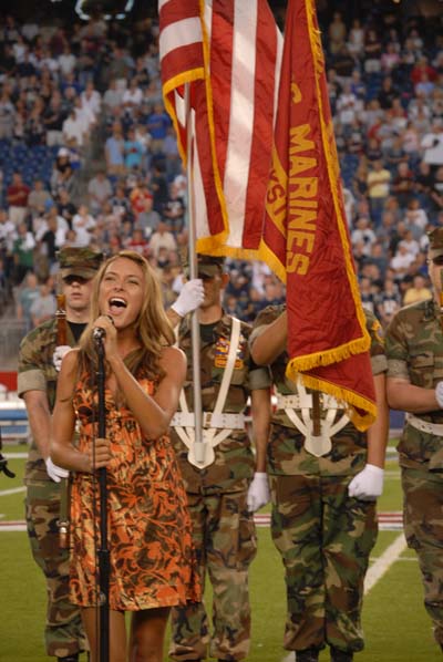 Photo of Julie Dubela singing the National Anthem at Patriots/Giants football game